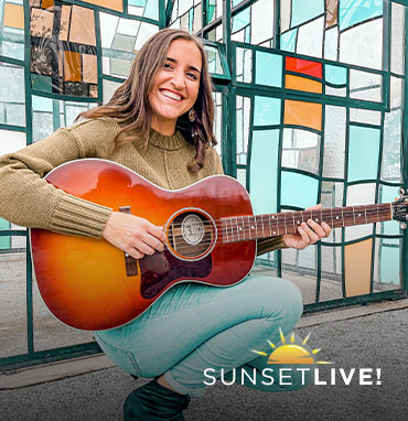 Allie Sawicki playing an acoustic guitar
