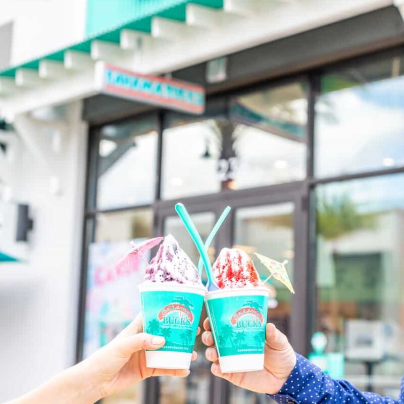 Hands raising cups of Bahama Buck’s shaved ice in a toast