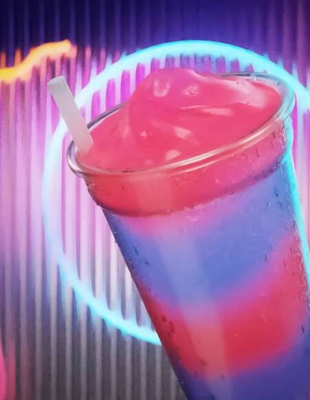 Colorful Fat Tuesday drink in front of a neon sign background