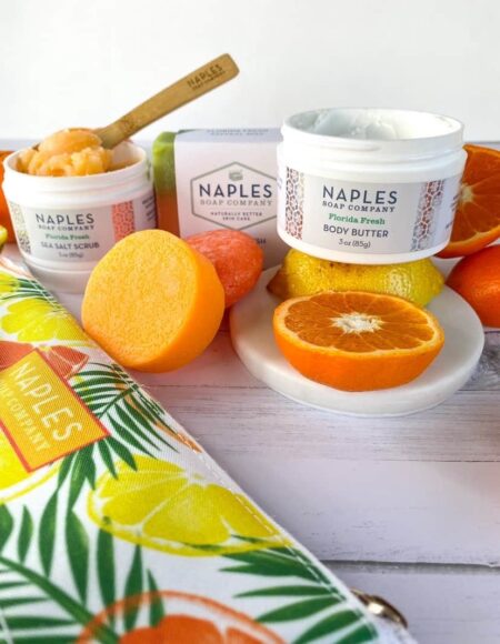 Florida Fresh body butter from Naples Soap Company next to sliced citrus