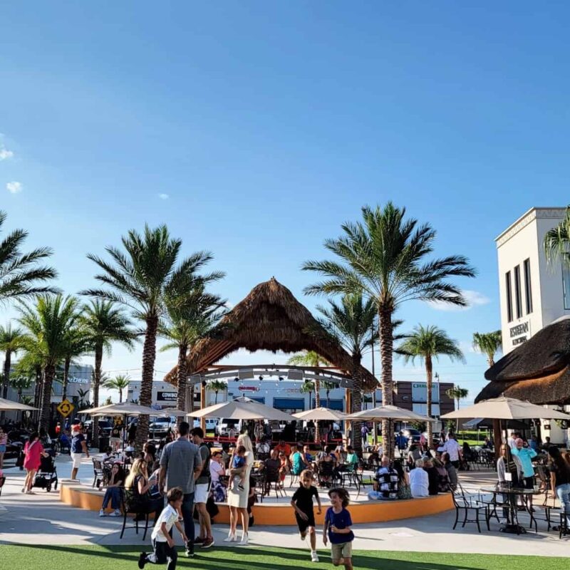 Niños y familias tocando y disfrutando de música en vivo en el escenario Promenade Plaza.