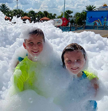 Young kids sitting in foam as part of Island H2O Water Park's family foam party