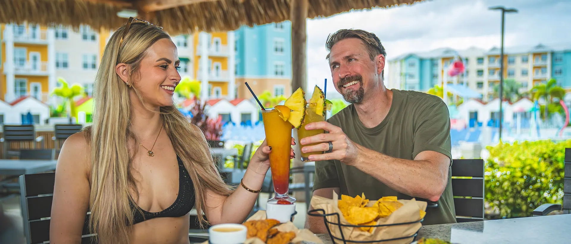 Couple toasting with drinks and snacks at Mango Moon Bar