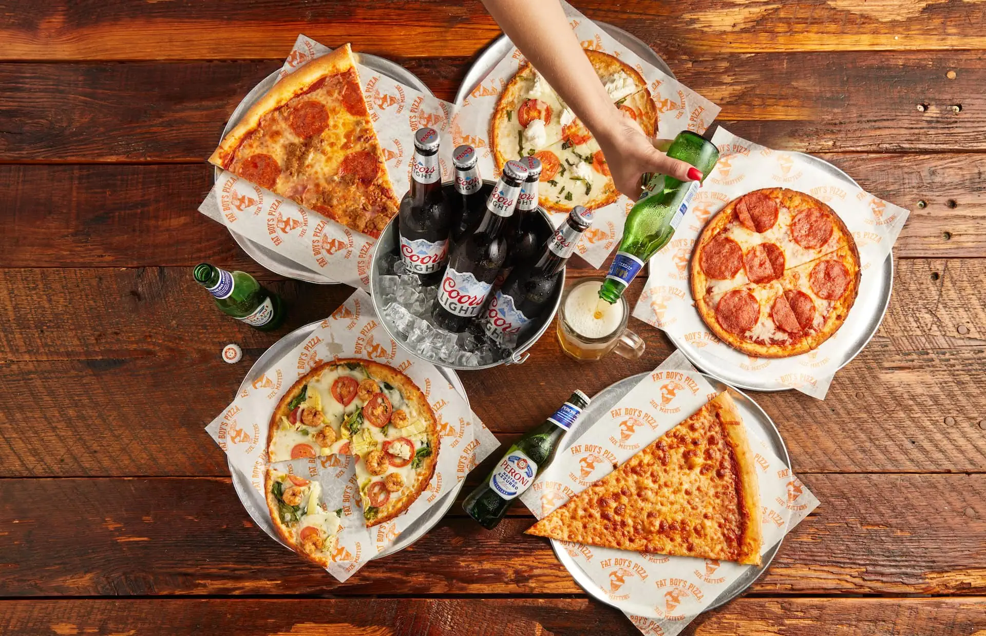 Assorted Fat Boy’s Pizza slices around a bucket of beer
