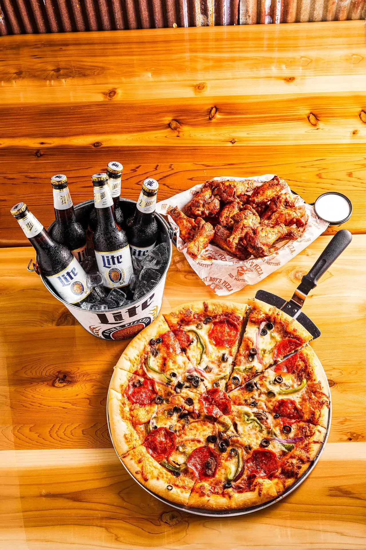 Fat Boy’s Pizza with wings and a bucket of bottled beers