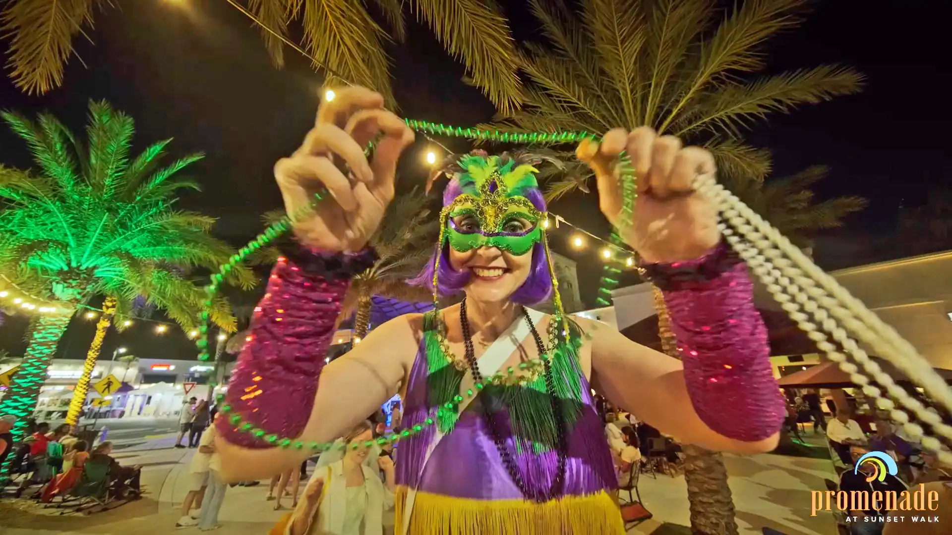Woman in a Mardi Gras mask holding a bead necklace